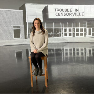 Image of teacher Melissa Statz Grandi sitting on the set of Trouble in Censorville